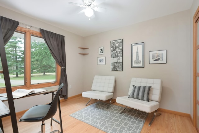 sitting room with light wood-style flooring, baseboards, and ceiling fan