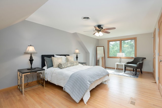 bedroom featuring baseboards, visible vents, and light wood finished floors