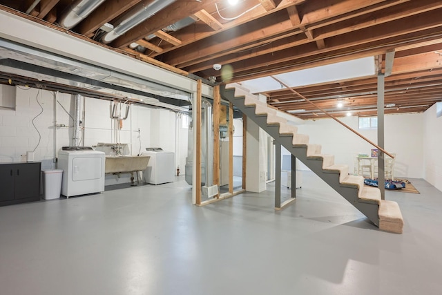 basement featuring independent washer and dryer, stairs, and a sink