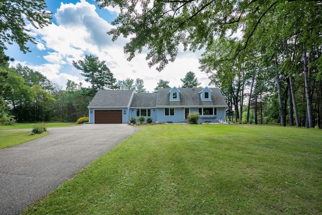 view of front of house with a front lawn, an attached garage, and driveway