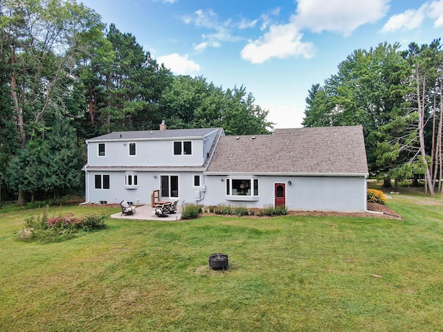 back of property with a yard, a patio, a chimney, and an outdoor fire pit