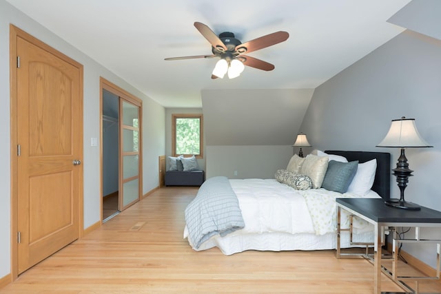 bedroom featuring light wood-style flooring, baseboards, lofted ceiling, and ceiling fan