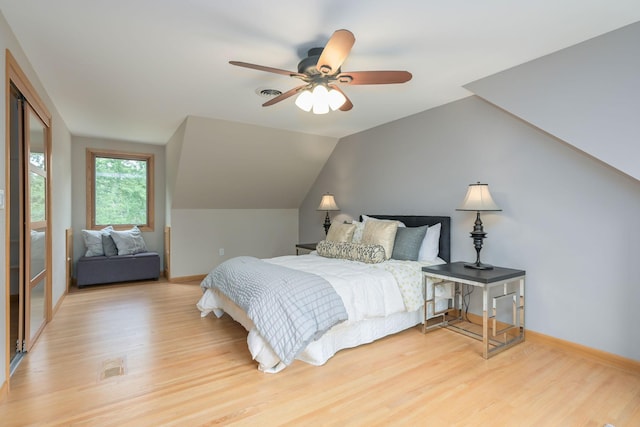 bedroom featuring baseboards, light wood-style flooring, a ceiling fan, and vaulted ceiling