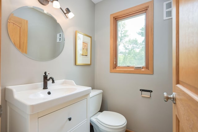 bathroom featuring visible vents, toilet, and vanity