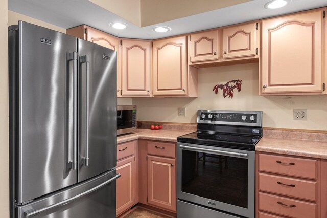 kitchen with appliances with stainless steel finishes and light brown cabinets