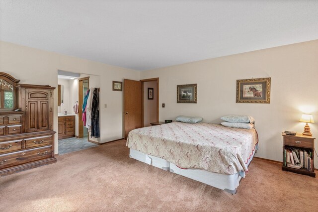 carpeted bedroom featuring a closet and ensuite bath