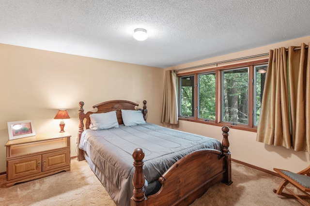 bedroom with light colored carpet and a textured ceiling