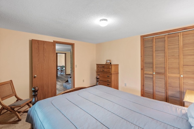 carpeted bedroom featuring a closet and a textured ceiling