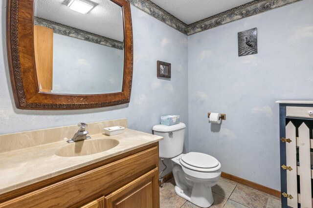 bathroom with a textured ceiling, toilet, vanity, and tile patterned floors