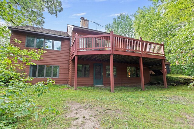 rear view of property with a yard and a wooden deck