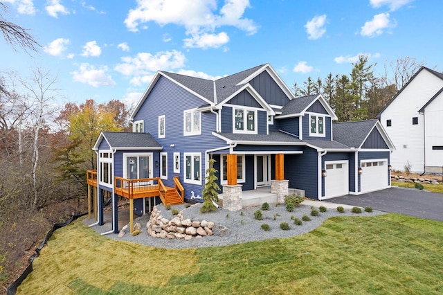 view of front of house with covered porch, a wooden deck, and a front lawn