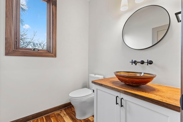 bathroom with vanity, wood-type flooring, and toilet