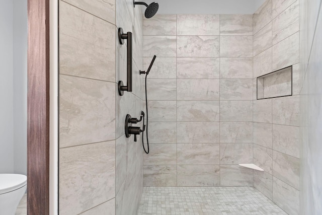 bathroom featuring toilet and tiled shower