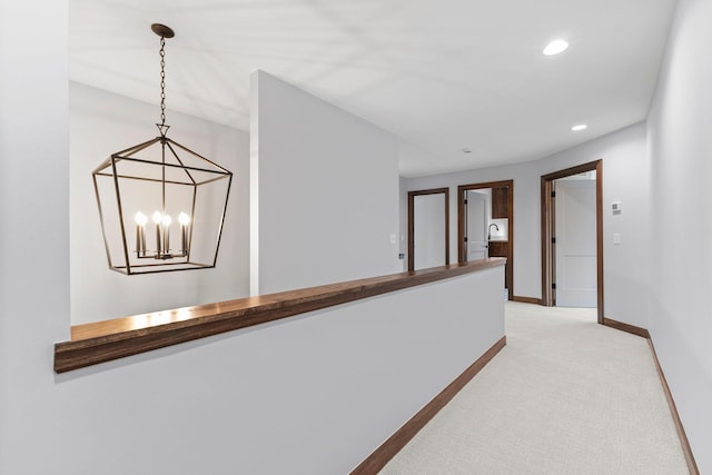 hall featuring a notable chandelier and light colored carpet