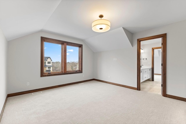 bonus room with light colored carpet, lofted ceiling, and sink