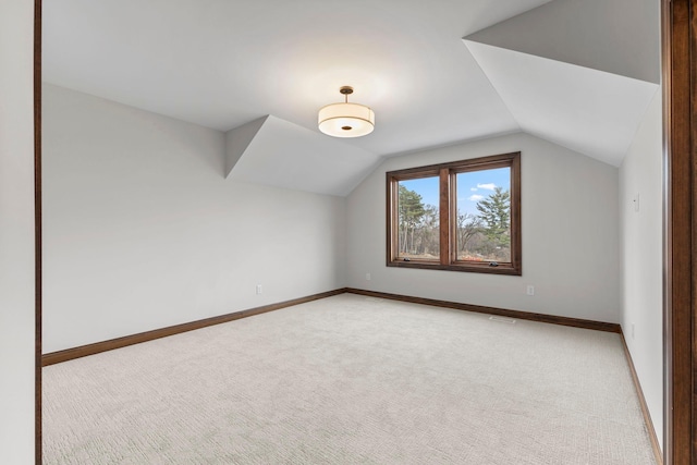 additional living space with light carpet and vaulted ceiling