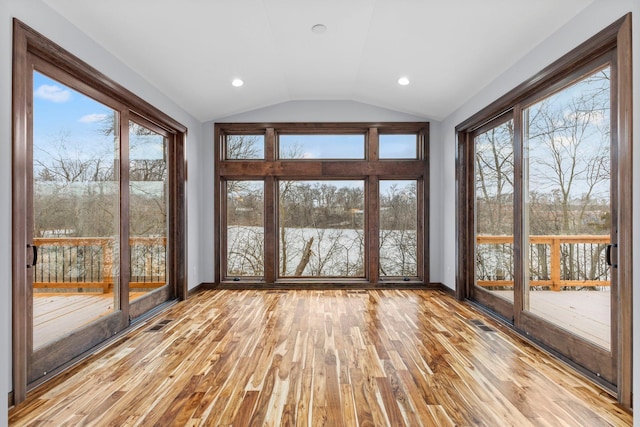 unfurnished sunroom featuring lofted ceiling and a healthy amount of sunlight