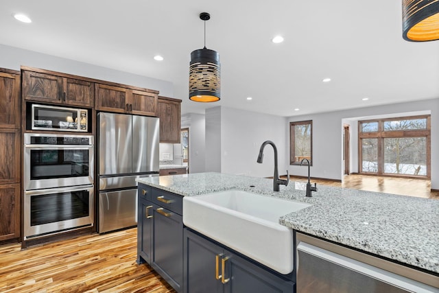 5534 Conifer Trl, Minnetonka, MN 55345 - kitchen with appliances with stainless steel finishes, a sink, pendant lighting, recessed lighting, and light wood-style flooring