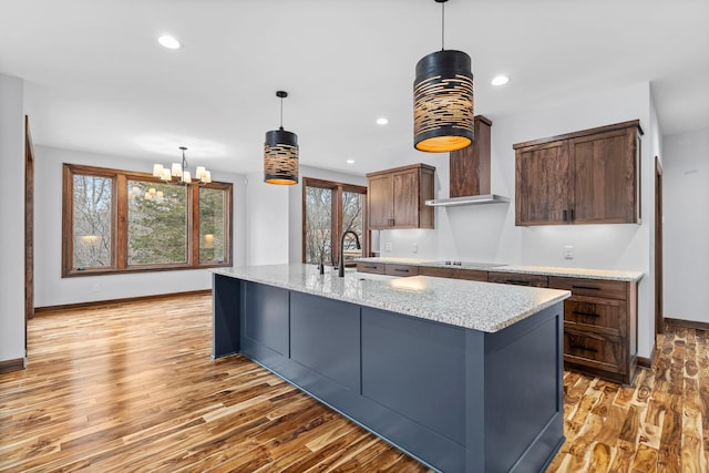 5534 Conifer Trl, Minnetonka, MN 55345 - kitchen with light wood-style floors, baseboards, decorative light fixtures, a chandelier, and light stone counters