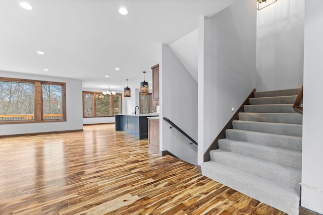 5534 Conifer Trl, Minnetonka, MN 55345 - unfurnished living room with recessed lighting, light wood-style flooring, a sink, and stairs