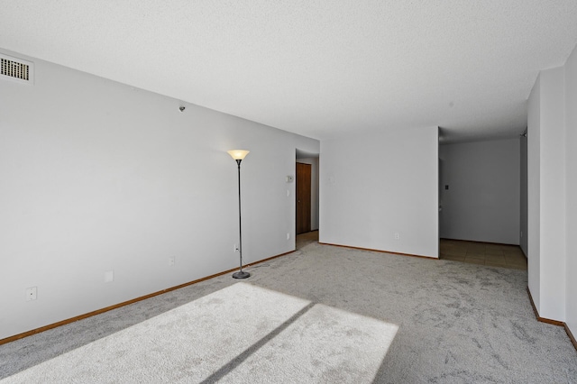 carpeted spare room featuring a textured ceiling