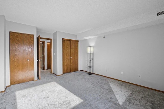 bedroom with a textured ceiling and light colored carpet