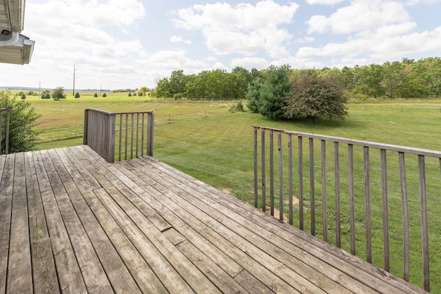 wooden terrace featuring a rural view and a yard