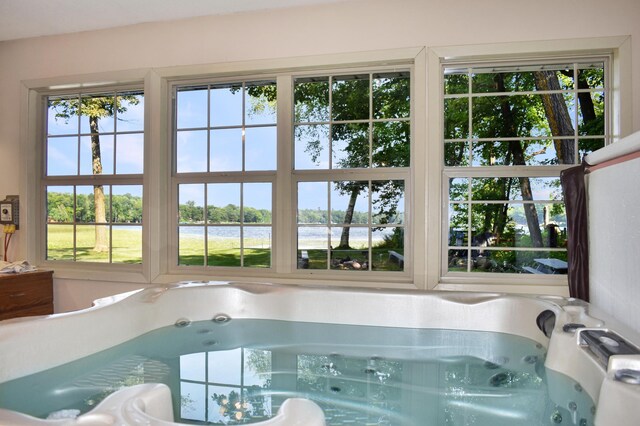 view of pool with a water view and an indoor hot tub