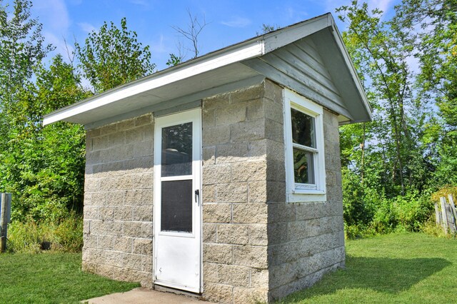 view of property exterior with an outbuilding and a yard