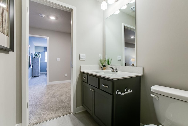 bathroom featuring tile patterned flooring, vanity, and toilet