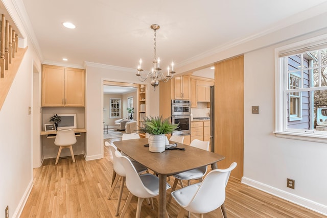 dining area featuring a notable chandelier, ornamental molding, built in desk, and light wood-type flooring