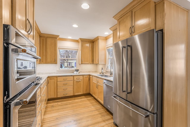 kitchen featuring light brown cabinetry, tasteful backsplash, sink, light hardwood / wood-style floors, and stainless steel appliances