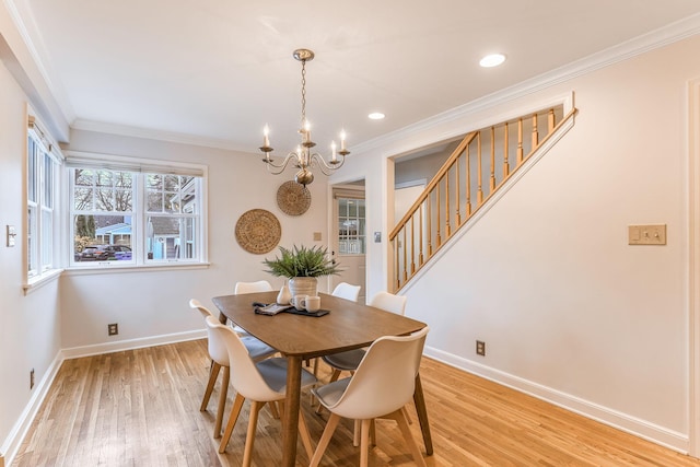 dining room with an inviting chandelier, ornamental molding, and light hardwood / wood-style flooring