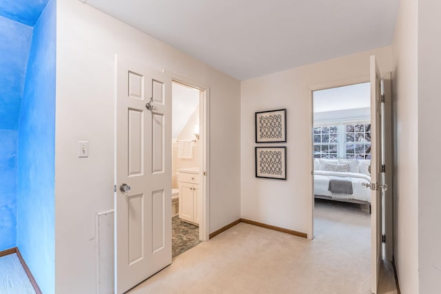 hallway featuring light colored carpet