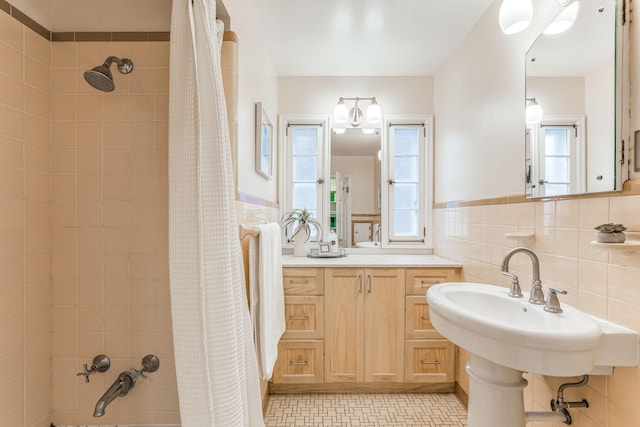 bathroom featuring double sink, tile walls, tile patterned floors, and shower / bath combo with shower curtain