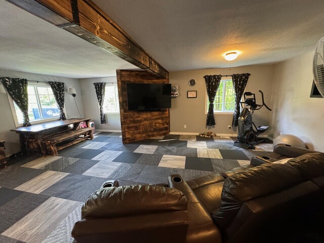 living area featuring dark carpet, a textured ceiling, and baseboards