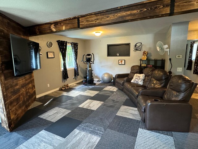 living area featuring beam ceiling and baseboards