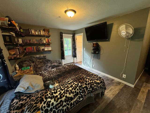 bedroom featuring dark wood-style floors, a textured ceiling, and baseboards