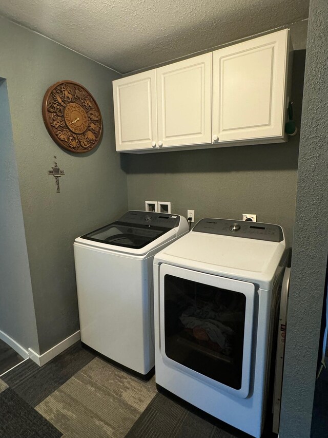 laundry area with cabinet space, a textured ceiling, baseboards, and separate washer and dryer