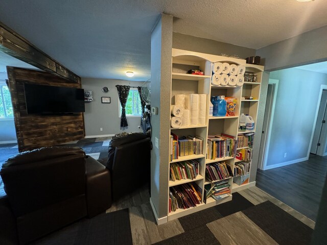 living area featuring baseboards and a textured ceiling