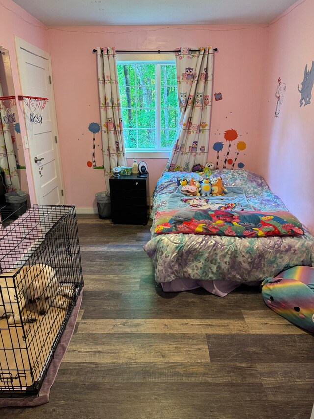 bedroom with dark wood-type flooring and baseboards