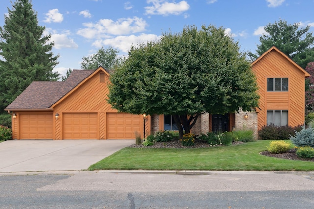 view of front of house featuring an attached garage, a shingled roof, brick siding, driveway, and a front lawn