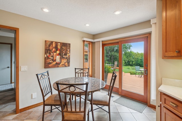 dining space featuring recessed lighting, a textured ceiling, baseboards, and light tile patterned floors