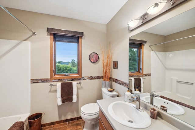 bathroom with toilet,  shower combination, wood finished floors, and vanity