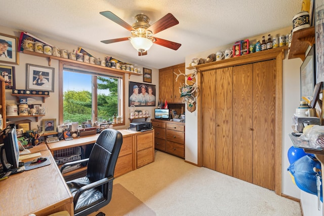 office area featuring a ceiling fan, light colored carpet, and a textured ceiling