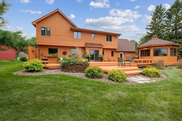 rear view of house with a gazebo, a lawn, and a wooden deck