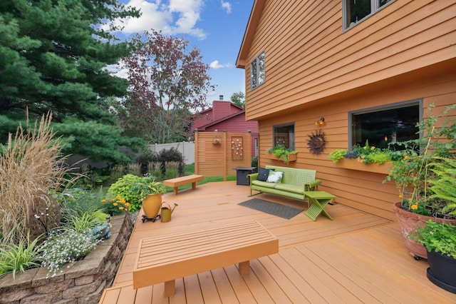 wooden terrace with outdoor lounge area and fence