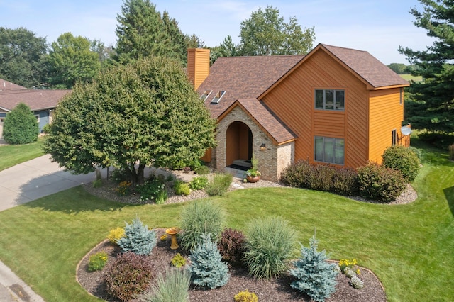 view of front of property with roof with shingles, a chimney, and a front yard