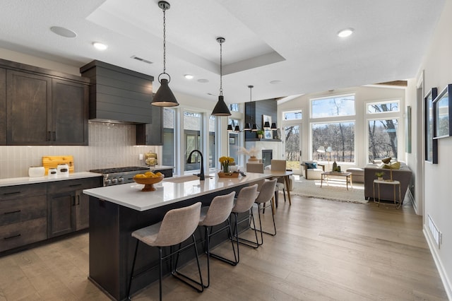 kitchen featuring light countertops, light wood-type flooring, a sink, and dark brown cabinetry
