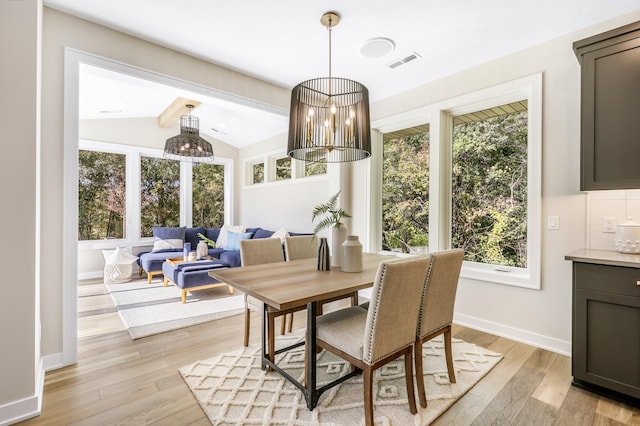 dining area featuring light wood-type flooring, lofted ceiling, and plenty of natural light